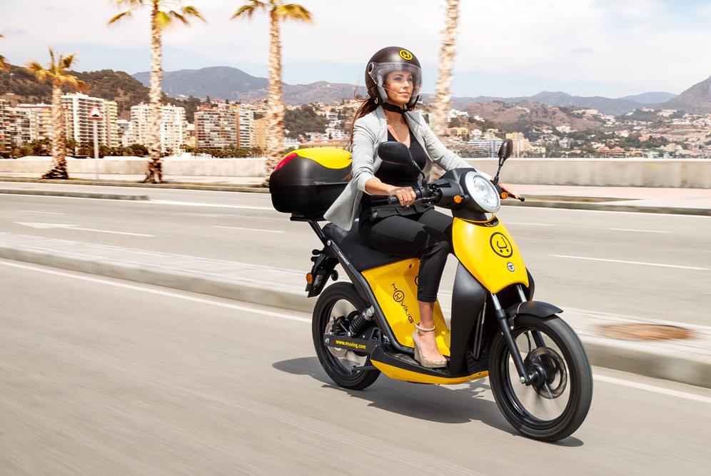 mujer en moto amarilla con casco